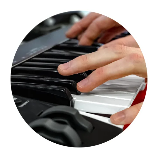 Hands playing black and white keys on Nektar SE61 midi keyboard, angled closeup view