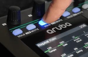 Nektar Aruba controller angled view showing blue-lit buttons and knobs with hand adjusting controls