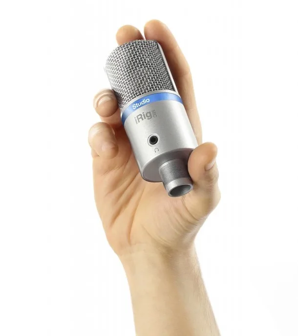 IK Multimedia iRig Mic Studio condenser microphone in silver, held in a hand against white background