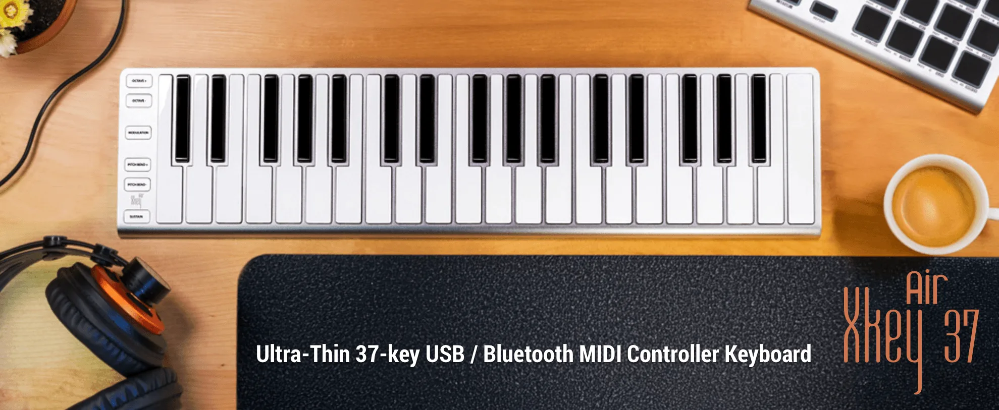 ESI Xkey Air 37 slim white MIDI keyboard on wooden desk with headphones, coffee cup, and computer keyboard visible