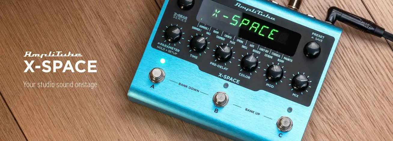 Bright blue Amplitube X-SPACE audio interface on wood surface, showing green LED display and multiple black control knobs