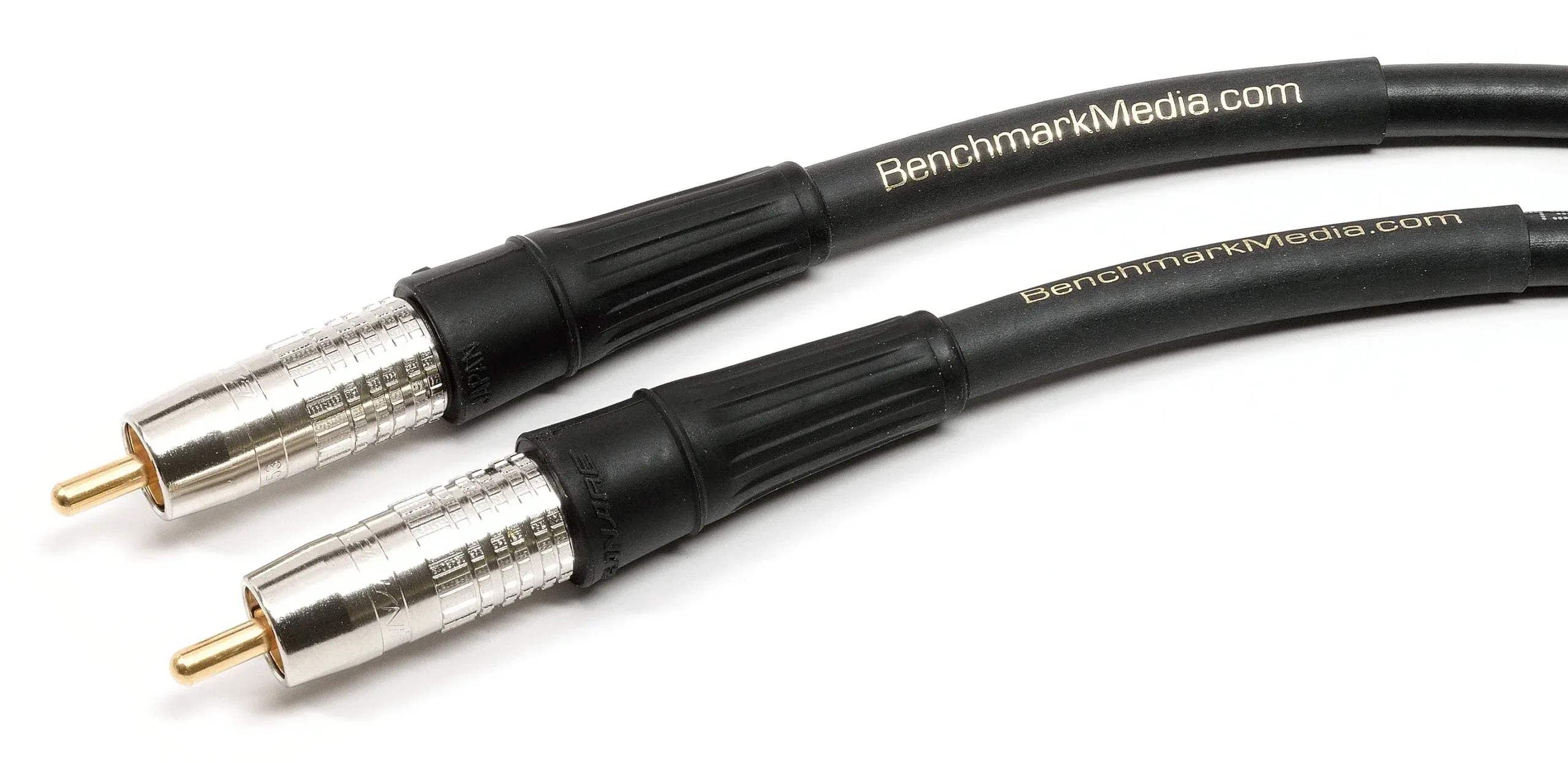 Two black Benchmark RCA cables with silver connectors and gold-plated pins, displayed at an angle against white background
