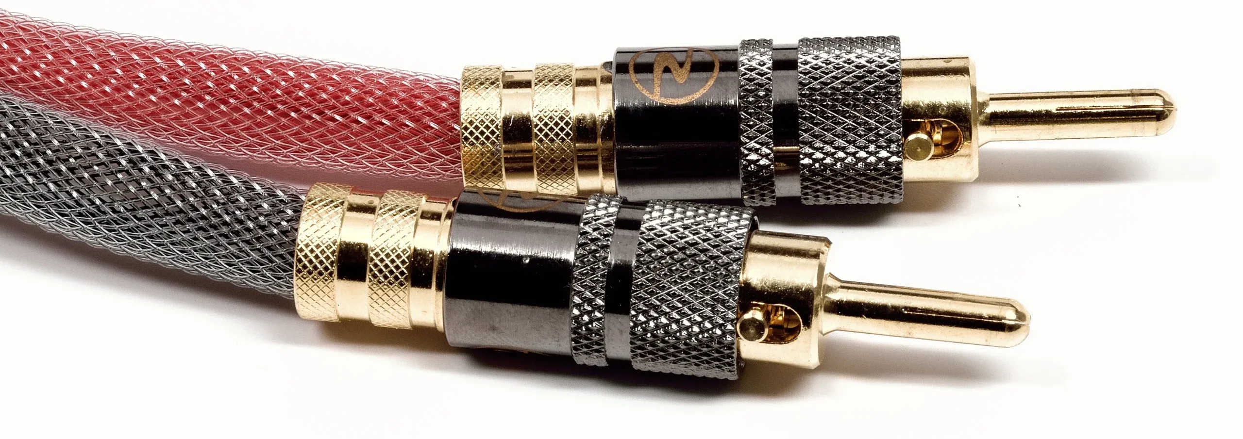 Two gold-plated banana plugs with red and black braided cable, angled view on white background