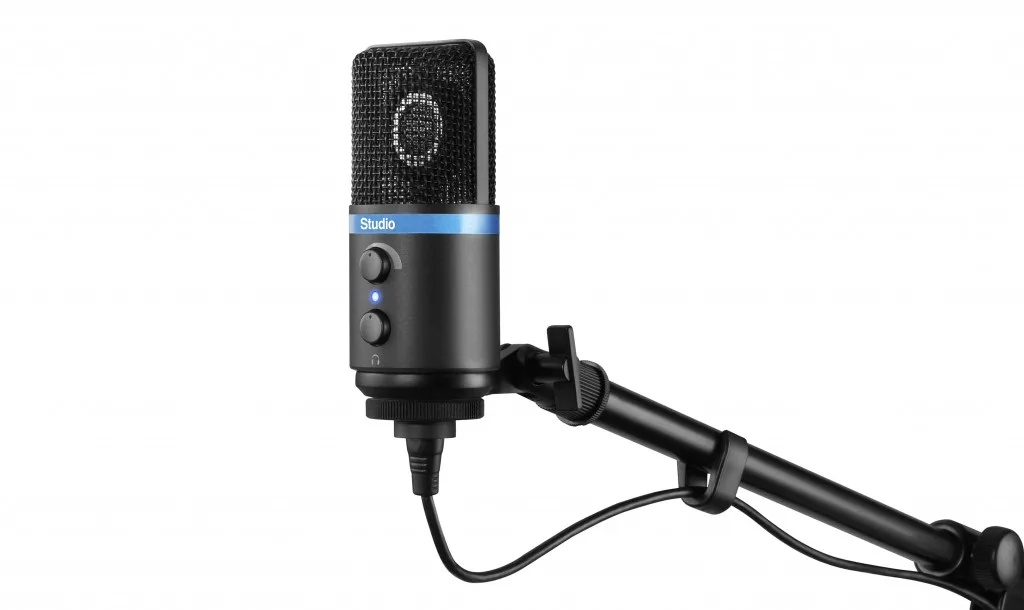 iRig Mic Studio Black condenser microphone with blue band, mounted on black tripod stand against white background