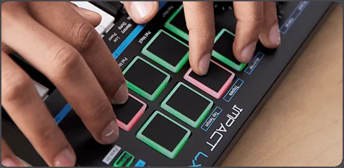 Hands playing Nektar Impact LX Mini, revealing illuminated green and pink touch pads from overhead angle