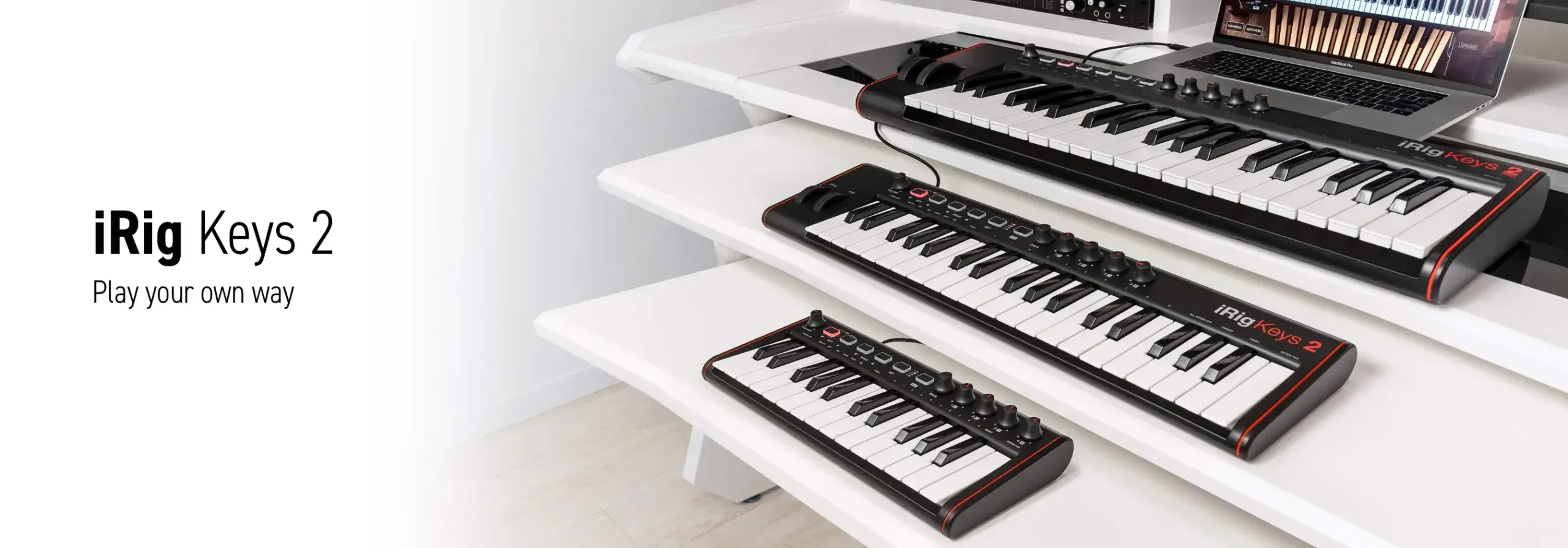 Three IK Multimedia iRig Keys 2 compact keyboards arranged in descending size order on white shelves, with laptop and larger keyboard visible above