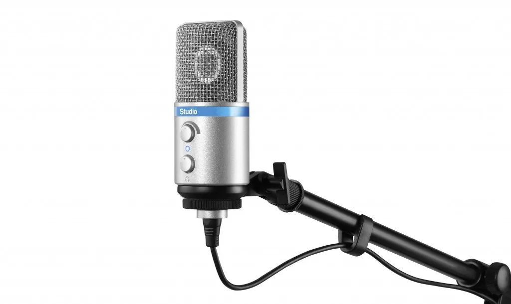 iRig Mic Studio Silver condenser microphone with mesh grille mounted on black boom arm against white background