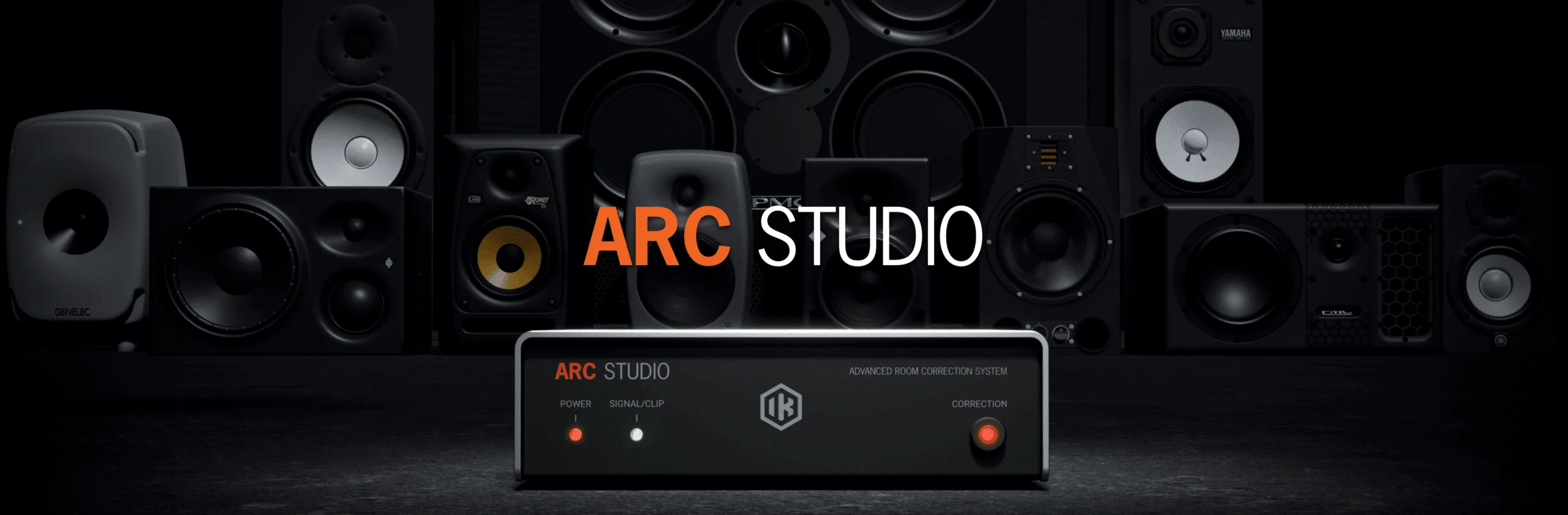 IK Multimedia ARC Studio advanced room correction system with control unit displaying power and signal indicators against dark studio speaker backdrop