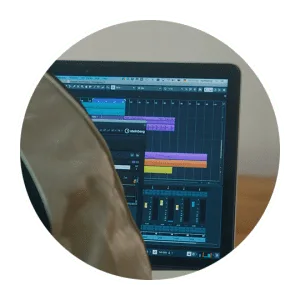 Laptop running a DAW session with coloured tracks