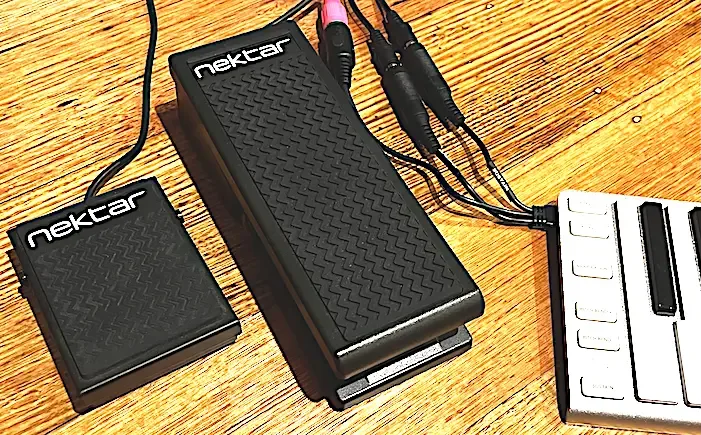 Nektar NP-1 expression pedal displayed with two black units and white piano keys controller on wooden surface