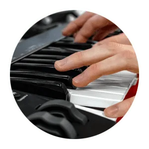 Hands playing black Nektar SE49 keyboard controller with white keys visible, shot from above
