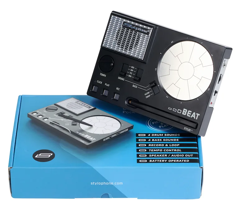 Stylophone Beat portable drum machine displayed next to blue packaging, showing touch stylus interface and illuminated grid screen