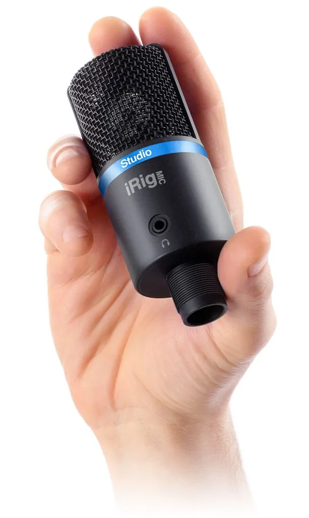 iRig Mic Studio compact condenser microphone held in hand, black mesh head with blue band, gray body, shown against white background