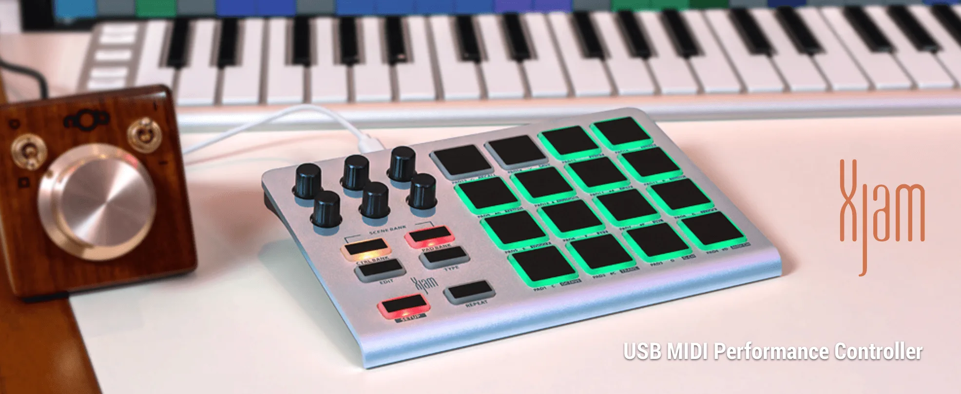 ESI Xjam USB MIDI controller with 16 illuminated green pads, knobs, and faders alongside keyboard and wooden control device
