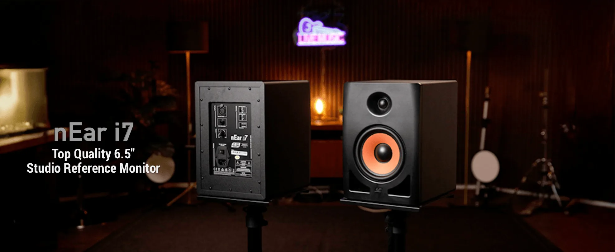 Black nEar i7 studio monitor with orange woofer, shown in dark studio setting alongside rear panel view